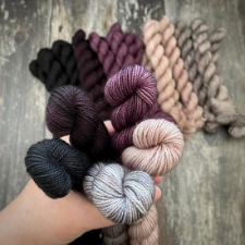 Mini skeins ranging from black to a deep purple to a soft ping to a light taupe neutral.