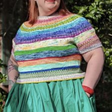 Colorful striped sweater with a bit of colorwork geometric patterning in some stripes.