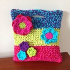 Crocheted tote with applique crocheted flowers in different sizes.