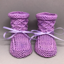 Booties with crisscross pattern on cuffs that looks like quilted fabric.