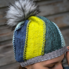 Hat knit in several colors forms gentle spiral pattern. A visible braid-like join marks each color transition.