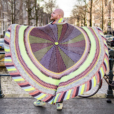 Round blanket features 5 colors of DK weight yarn. Begin in the center with striped short row wedges, then work your way to the border with plush textures and slip stitches.