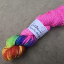 Very bright pink yarn with about a third of the skein in a rainbow variegated colorway.