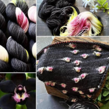 Nearly black variegated yarn with cream and fuchsia patches. Shown knitted up to pool the pink portions on the near-black background.