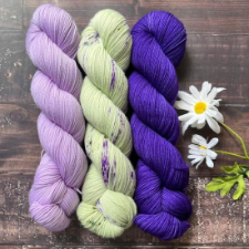 Three skeins, pale lavender, cream with purple streaks and bright purple.