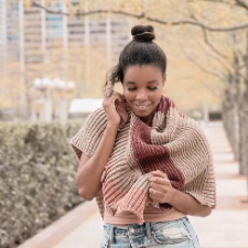 Rectangular wrap with buttons at the end, in sections of single-color brioche and garter stitch in different warm shades.