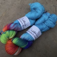 Two skeins that are about two thirds aqua and one third rainbow colors.