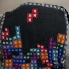 Lap blanket with colorwork of Tetris game pieces falling