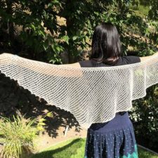 Triangular shawl with netted lace pattern.