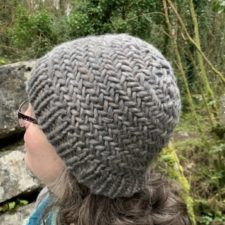 Bulkly yarn beanie with ribbed brim and braided texture.