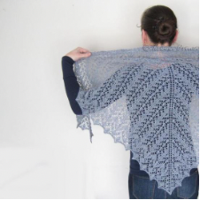 Triangular laceweight shawl in pattern where the lace columns are perpendicular to the bottom edges of the triangle, meeting at the spine.