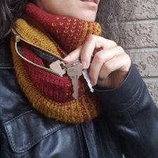 Wearer puts keys into a zippered pocket in a doubled up cowl.