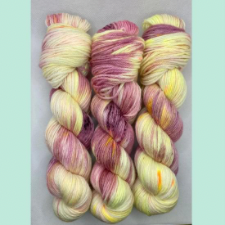 Non-superwash yarn in palest yellow and a pink the inside of conch shells.