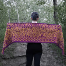 Long, rectangular colorwork shawl with birds and geometric shapes in two colors.