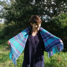 Crocheted plaid rectangular shawl with fringe.