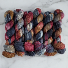 Variegated yarn in deep blues, greens and reds with splashes of white and brown.