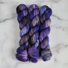 Deep purple variegated yarn with splashes of paler purple and bronze.