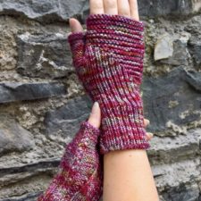 Fingerless mitts with vertical and horizontal textured lines coming together like a miter. Braided cable down the length, starting at the thumb.