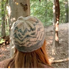 Colorwork hat with a mountain landcape on it.
