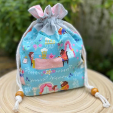 Drawstring project bag with Beauty and the Beast-theme fabric has soft rope drawstrings that end in large wooden beads.
