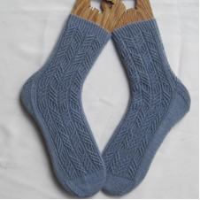 Delicate, geometric four-strand cables cover much of this textured sock.
