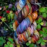 Bright, variegated yarn against leafy background