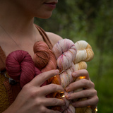 Dyer holds four skeins from light to dark