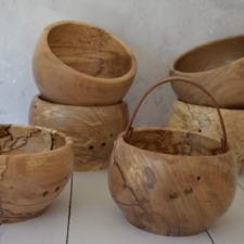 Wood yarn bowls with dramatic wood grain. Some have leather handles.