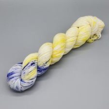 Bright lemon color in tonal yarn. Blueberry speckles at one end.