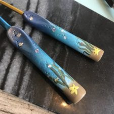 Ergonomic crochet hook with undersea scene of plants, fish and a starfish.