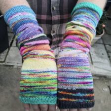 Stockinette wristwarmers, about 12 inches long, in rainbow variegated yarn.