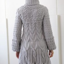 Long-sleeve thigh-length coat has several kinds of cables throughout.