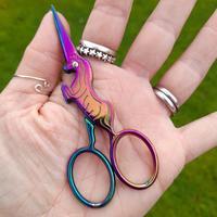 Titanium-finish scissors shaped like a unicorn, with the horn as the point.