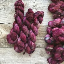 Rich, rose color tonal yarn skeins.