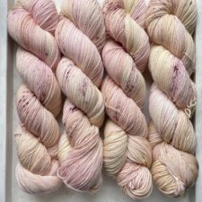 Four twisted skeins in creamy pastels like yogurt with fruit.