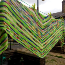 Triangular shawl with v-shaped stripes.