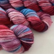 Bright, variegated yarn in mainly red tones.