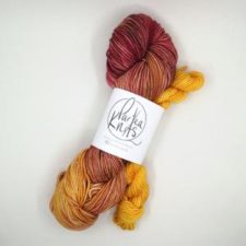 Sock set with warm tones. Heel and toe mini skein picks up the lightest and brightest shade in the variegated main skein.