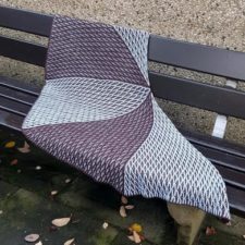 Brioche semicircular shawl in two colors, alternating the dominant color in five triangles that come together along the top edge.