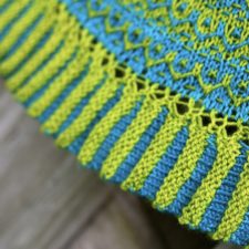 Intricate two-color shawl with trapped floats forming a delicate zigzag.