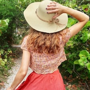 Model in Captiva crop top, sun hat and full skirt walks away from the camera.