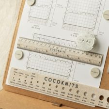 Cocoknits ruler and needle gauge, shown with magnetic project board and row counter.