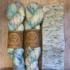 Variegated and speckled yarn in cool tones with sock tube.