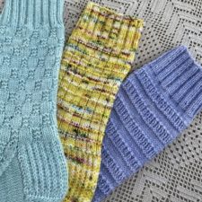 Three textured knitted socks, a rib, horizontal strips and a checked pair in texture.