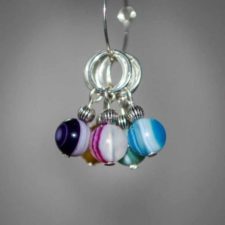 Round stitch markers with beads drilled so that the veins in the agate hang vertically. Small silver bead sits atop each main bead.