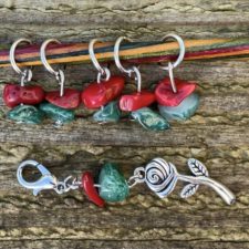 Silver rose charm with contrasting polished stones on lobster claw, plus five stitch markers made of the polished stones.