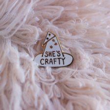Witch’s hat-shaped pin that says She’s Crafty on it.