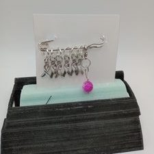 Metal stitch markers in the shape of lapel ribbons people wear for causes. Set includes one progress keeper