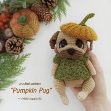 Crocheted dog with sweater and pumpkin hat.