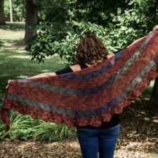 Wavy-edge crocheted crescent shawl in thick stripes. Alternating stripes are transparent.